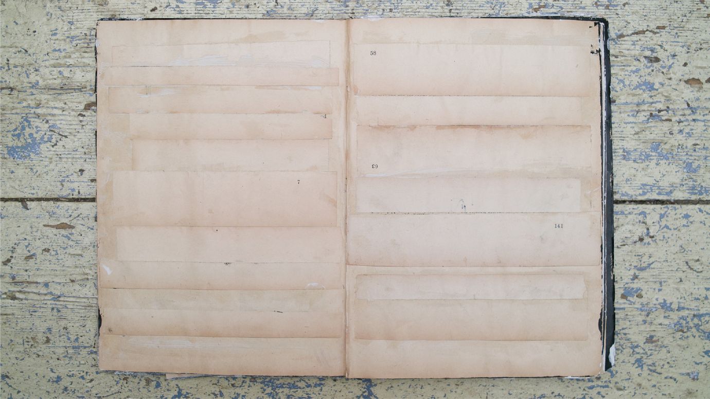 A collage book with an almost empty double-page spread. Glued onto it are empty pieces from other pages, with several page numbers as the only text visible.