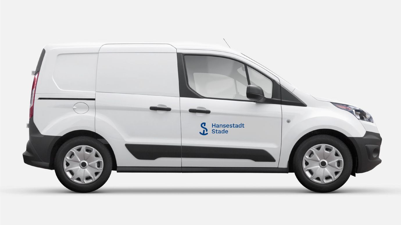 White box wagon from the side, blue Hansestadt Stade logo on the door.